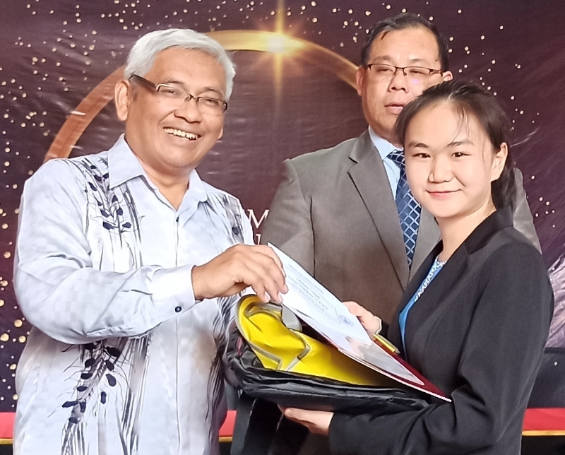 涂瑜萓（右）从霹雳行政议员阿兹巴里（左）的手中接过奖。中为莫哈末苏海米。