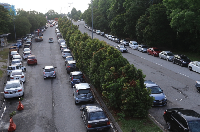 在前往沙登医院的道路两旁仍停满车辆，排列成4条车龙的面貌。