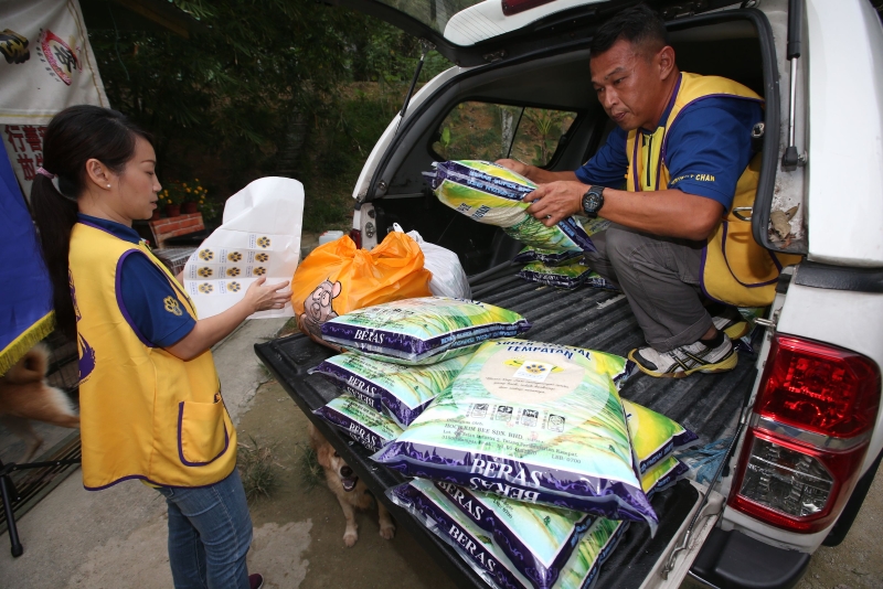 怡保万里狮子会的志工团队搬运粮食给谢其胜。