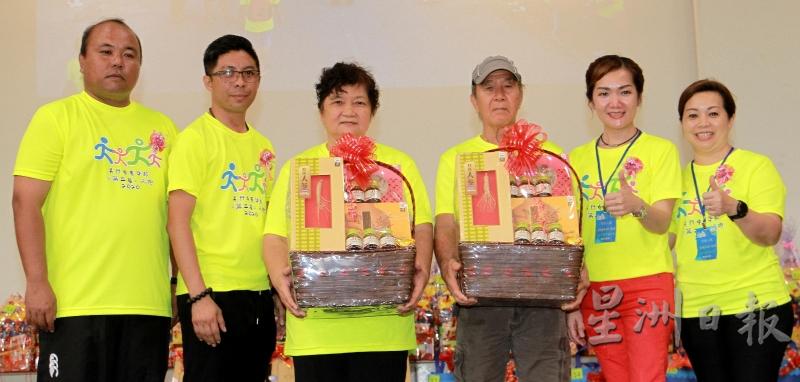 主办单位颁保健礼篮予最年长参与者徐凤英与刘洲（左三及四）及，以表扬他们的体育精神。（图：星洲日报）