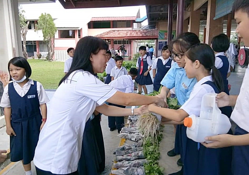 沙令学生在新年前，将所收成蔬菜卖给老师及家长。