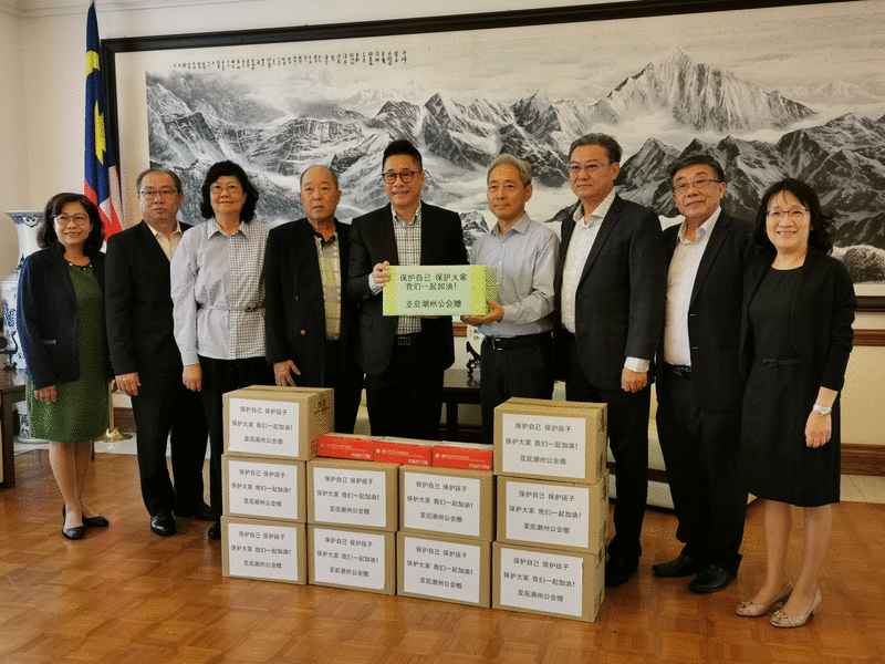 蔡顺平（左五）代表亚庇潮州公会移交50箱高级乳胶手套予中国驻庇总领馆，由吴晓晴（右四）代收。