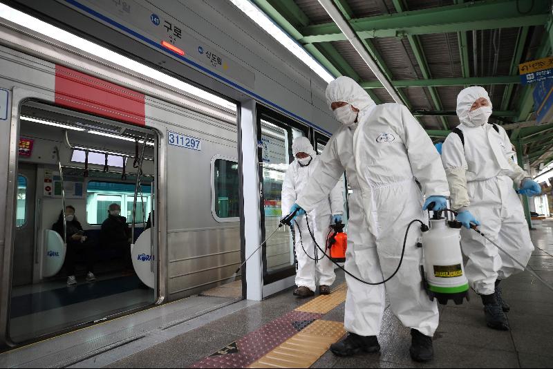 3月12日，首尔市防疫人员在地铁车厢内进行消毒作业。 （图：法新社）