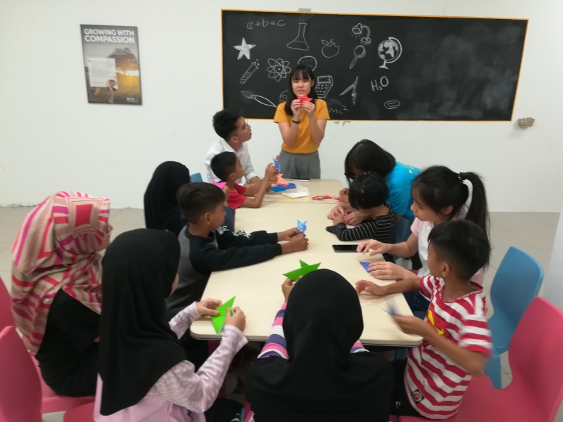 除了为小孩们提供马来语，英语和数学的补习班，志工老师也会教导小孩手工制作。