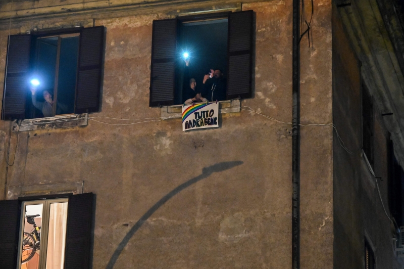意大利疫情大爆发后，当局要求民众待在家中隔离。不少人在晚上亮灯，在艰难时刻相互支持和鼓励。（法新社照片）