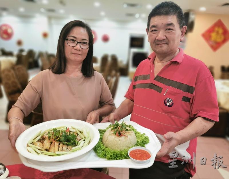 徐福祥（右）与锺宜妹展示独家烹制的芽菜白斩鸡及特制辣椒酱料。