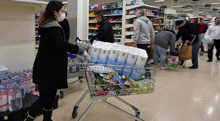 A woman buying toilet paper at a supermarket in London. AFP
