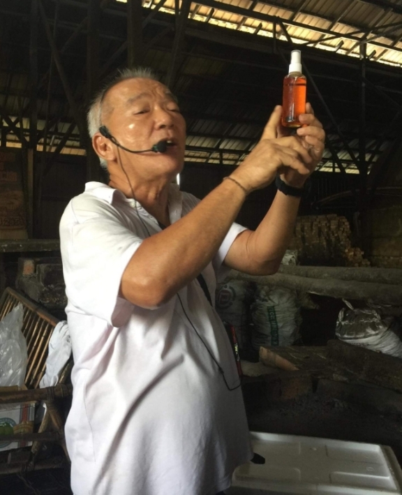 蔡招安正用热情的方式向学记们介绍炭窑产品——木醋液。