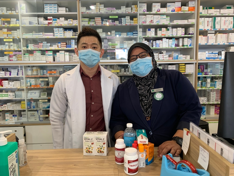 张佳盛（左）与店员阿蒂佳说，人们现在会到西药行购买加强免疫力的药品。