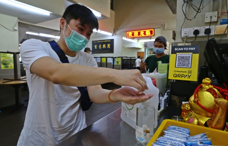 茶室业者在柜台处置放消毒搓手液，供前来打包的顾客使用。