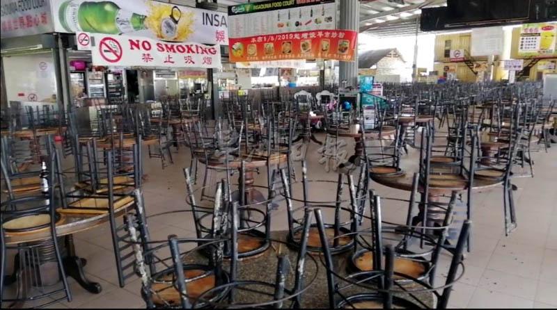 大山脚甘榜峇鲁点心城的熟食摊贩照常营业，但业者为了避免违反禁令，把椅子都倒叠在桌子上。
