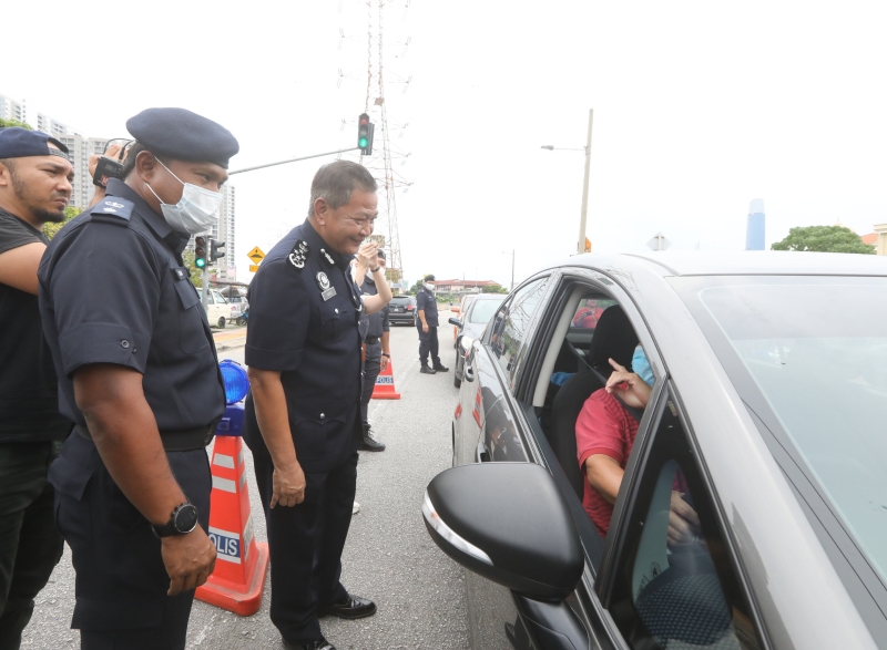 阿都哈密（右）提醒来往轿车司机留守家中。旁为拉惹阿哈。
