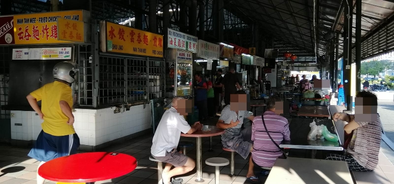 峇央峇鲁小贩中心内，可见顾客打包后直接坐下聚集闲聊。