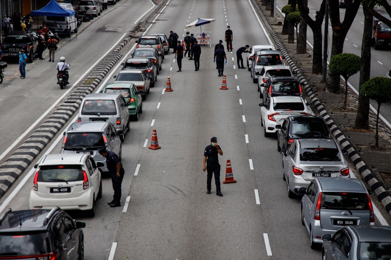 警方在敦李孝式路设路障，检查来往车辆，并劝告民众不要随意外出。