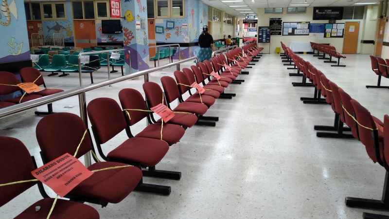 医院的座位贴上告示，间隔而坐，防止病毒传播。