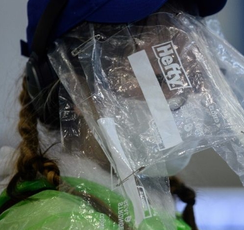 A passenger wears plastic bags over her face to protect against infection at Hong Kong's airport. AFP