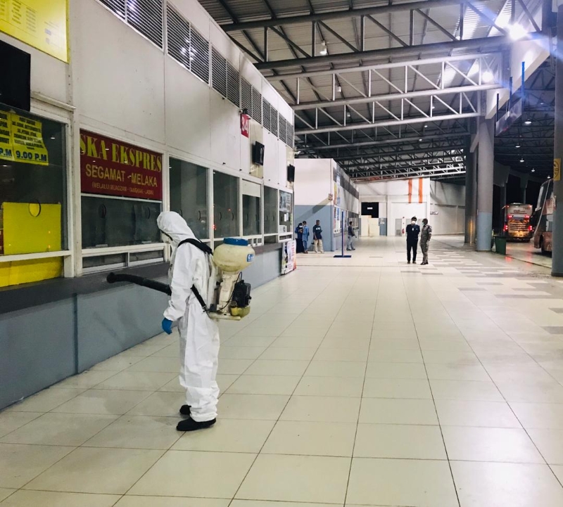  关丹市议会队伍全副武装上阵，在夜晚时分消毒整个巴士总站，以防病毒散播。
