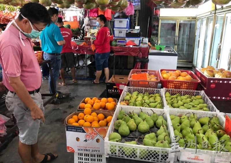大部分顾客不忘戴着口罩前来选购水果。