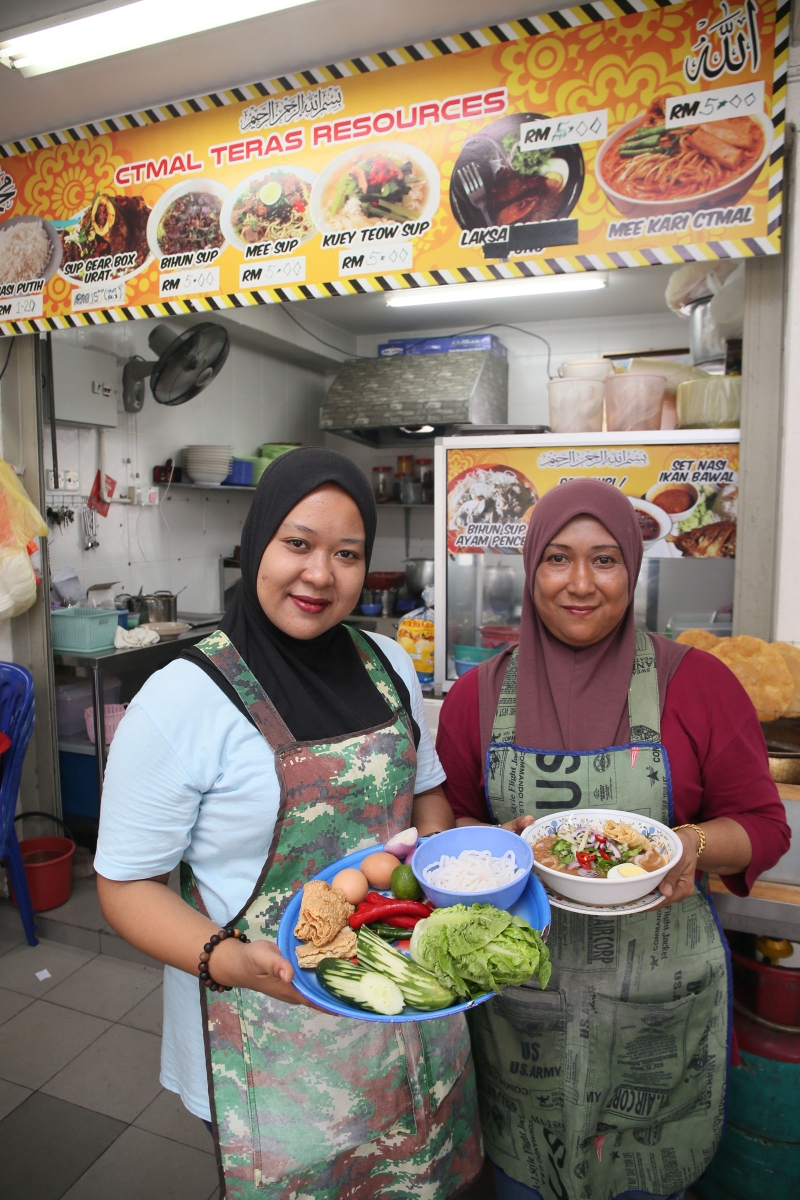 友族母女档丽恩（左）及西蒂掌厨熬煮的槟城版马来亚参叻沙，令人回味无穷。