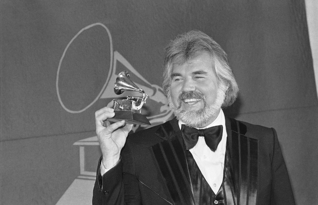 肯尼罗杰斯生前有24首排行冠军金曲，曾6度赢得乡村音乐奖，并获得3座格林美音乐奖肯定。这是他1980年拿下格林美音乐奖的留影。
