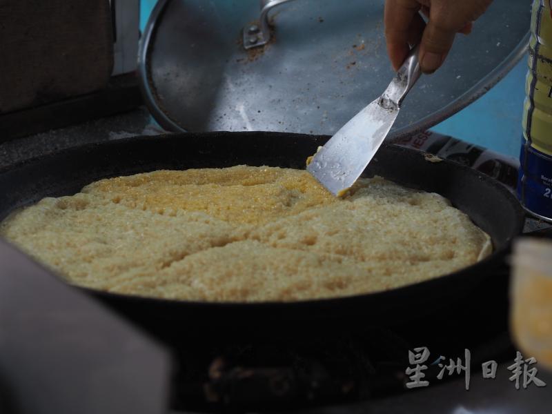 麻坡一家摊车的慢煎粿是先抹上牛油，再撒配料。