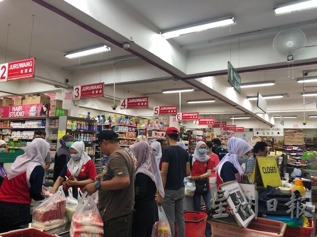 新邦令金超市依然人潮汹涌，民众在收银处排队等候结帐。（图：星洲日报）