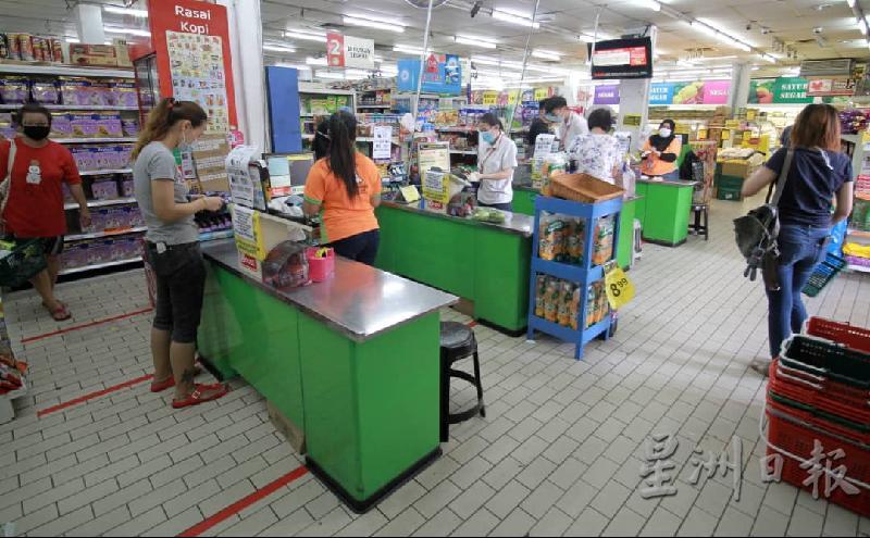 超市收银柜台处已经划上格子，让排队付钱的顾客保持社交距离。