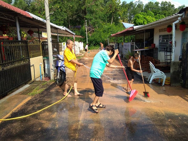 居民在水灾隔日忙著清洗黄泥。