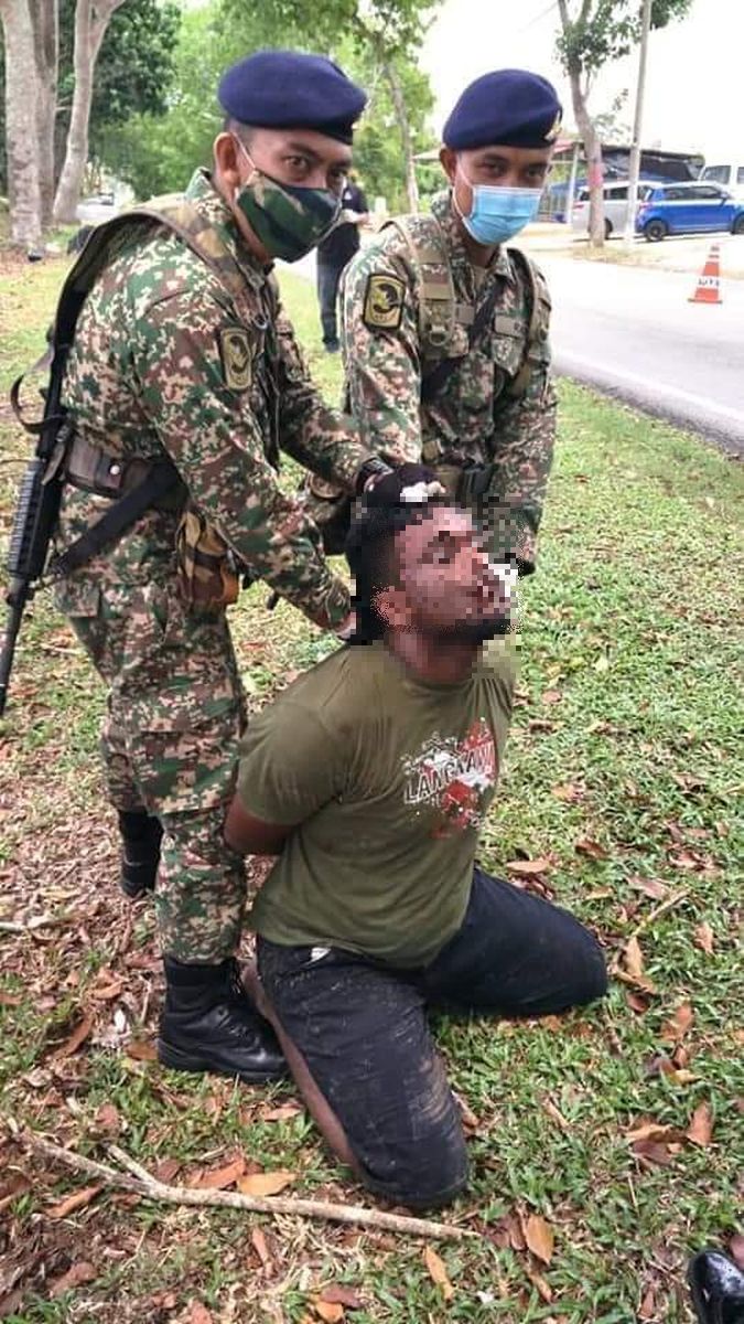 网民传上脸书的照片，可见两位军人箝制一名男子。