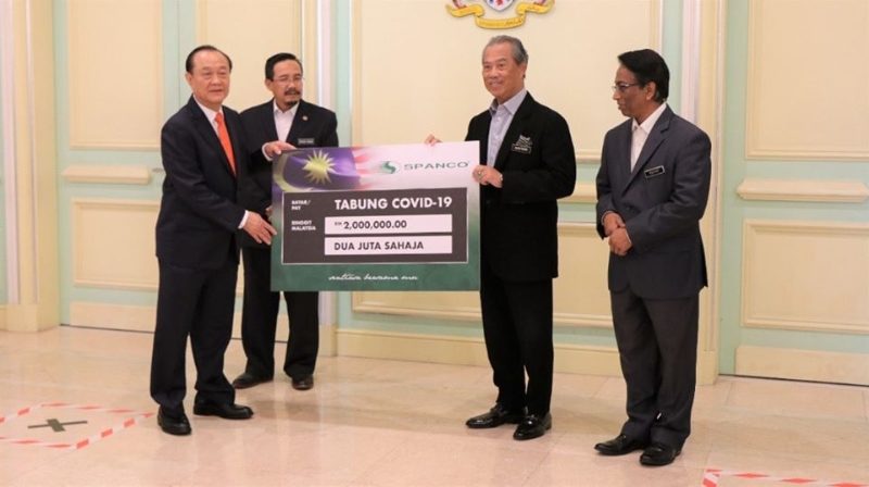 陈华春（左）代表SPANCO公司移交200万令吉模拟支票给慕尤丁（右二）。