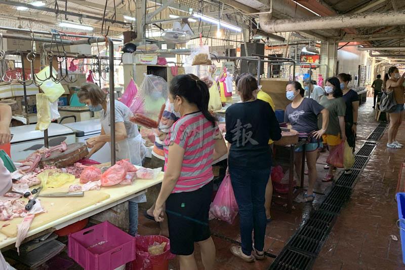 民众在菜市场排队购买猪肉。
