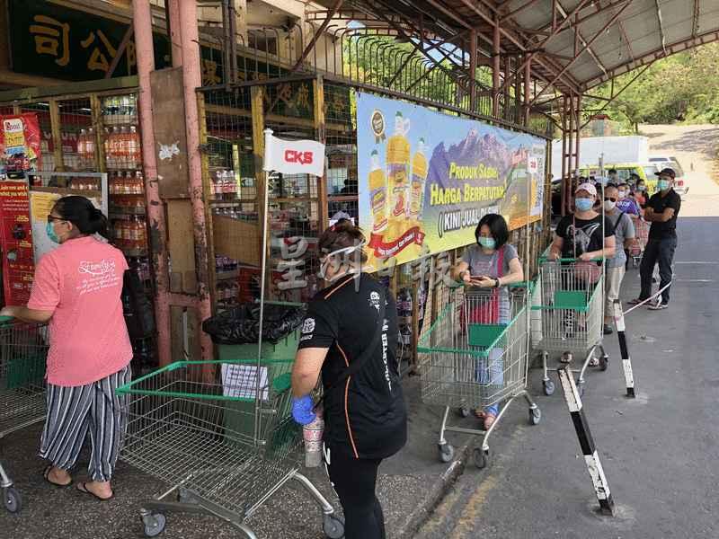 东贡岸CKS超市外，民众每人推着手推车，排队等候进入超市。