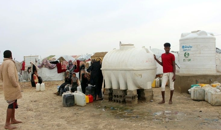 Yemenis fill jerricans with water from reservoirs at a makeshift camp for displaced people who fled fighting between the Huthi rebels and the Saudi-backed government. AFP