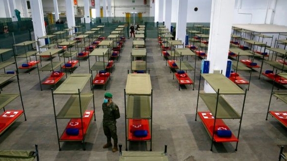 A Spanish soldier stands next to beds set up at a temporary hospital in Barcelona. AFP