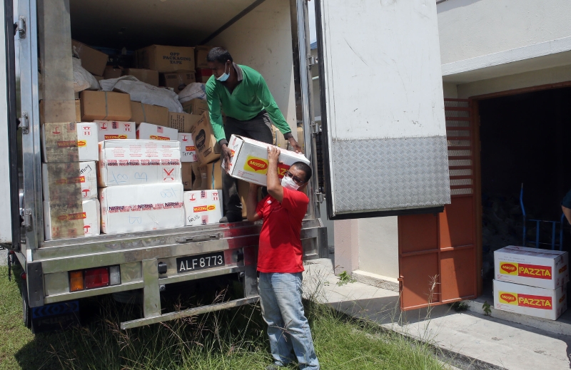 罗里司机把金马仑菜农捐献的蔬菜送到集散物资的行动中心。