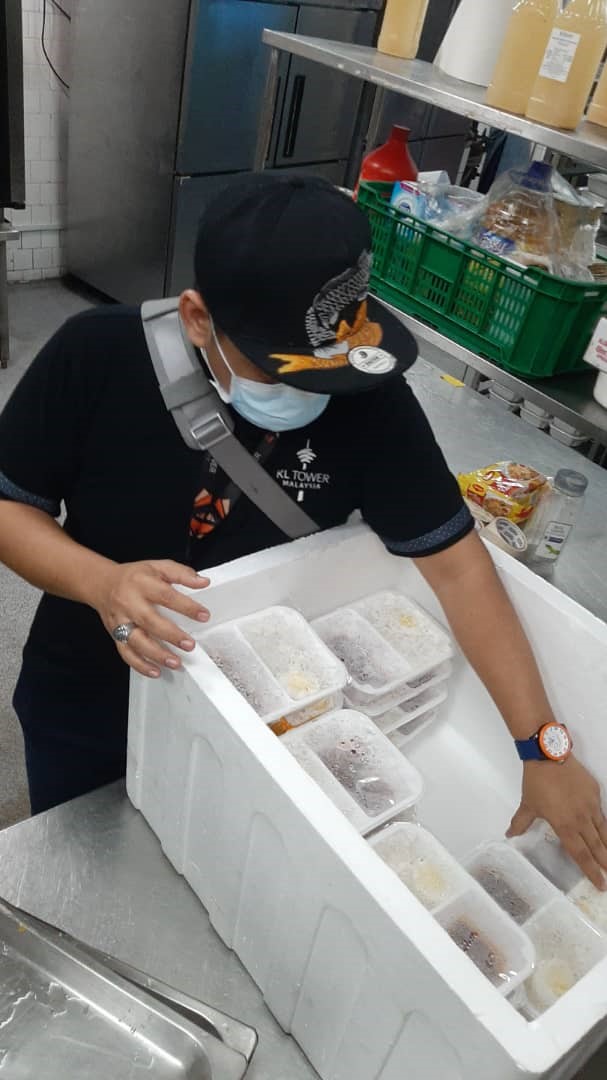 亚洲厨房的工作人员在为餐盒做最后准备，装箱送去双溪毛糯政府医院。