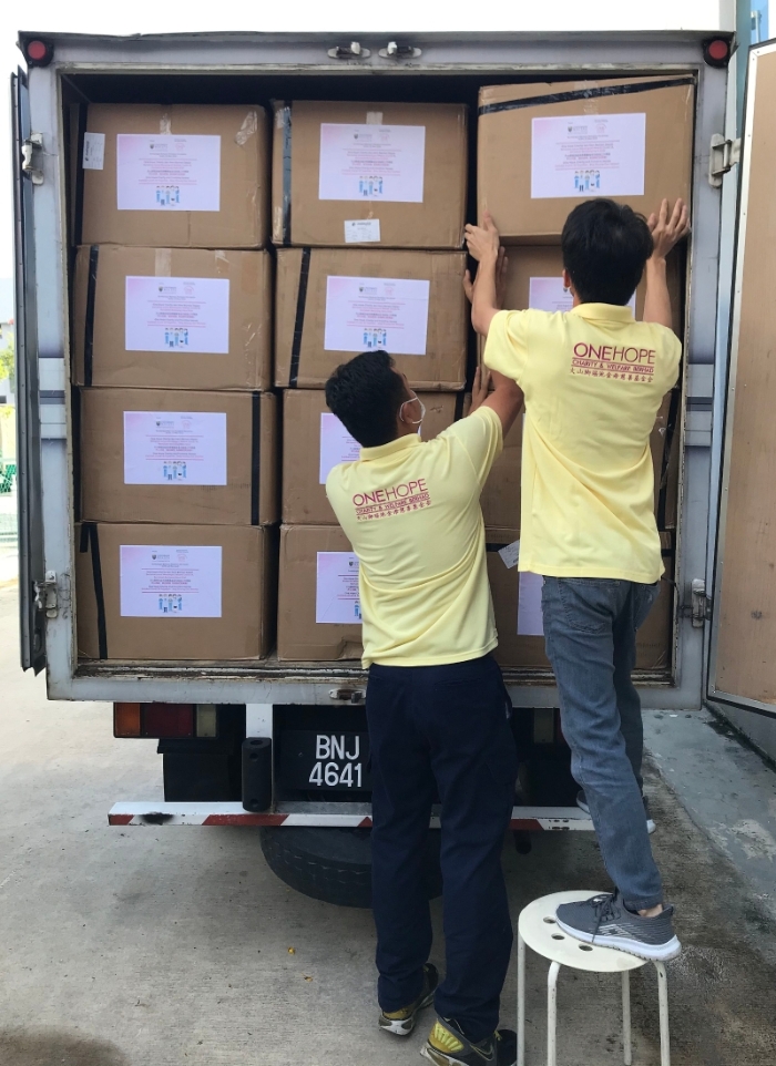 团队正把5万个医用口罩及医疗物资搬运上罗里，准备送往马大医院。