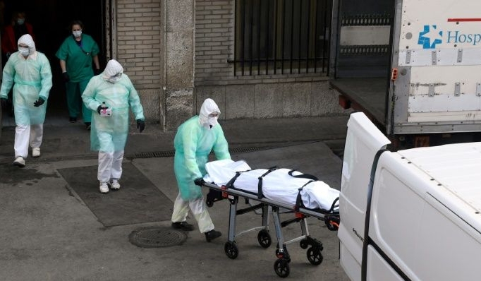 A health worker carries a body on a stretcher outside Gregorio Maranon hospital in Madrid. AFP