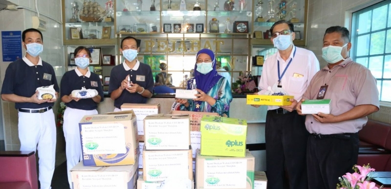 陈治谓（左三）将包装好的物资移交给麻坡卫生局负责人。
