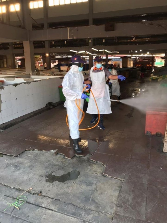 全副武装的消毒人员，在瓜雪县议会辖区5所公市进行消毒工作。