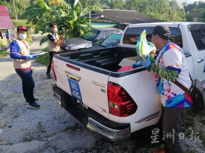 天灾委员会官员在县议会执法人员的陪同下，载了一车米粮在新古毛派送予急需援助的贫困家庭。