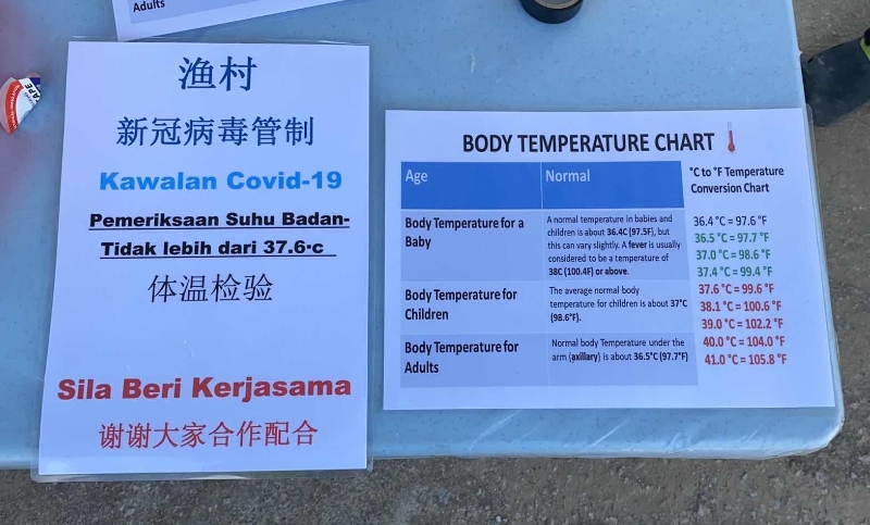 在道闸前，村民张贴告示牌，让入村者接受测量体温，并接受查问。
