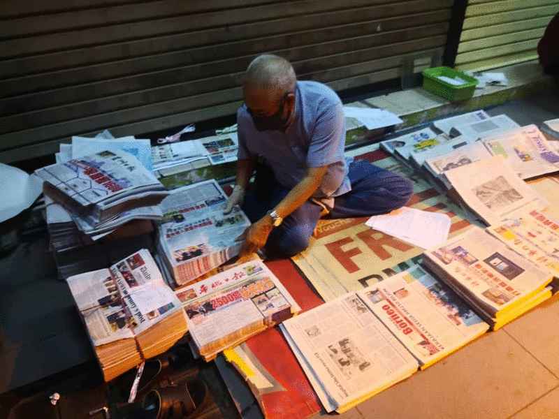 派报员正在折叠各语文报纸。