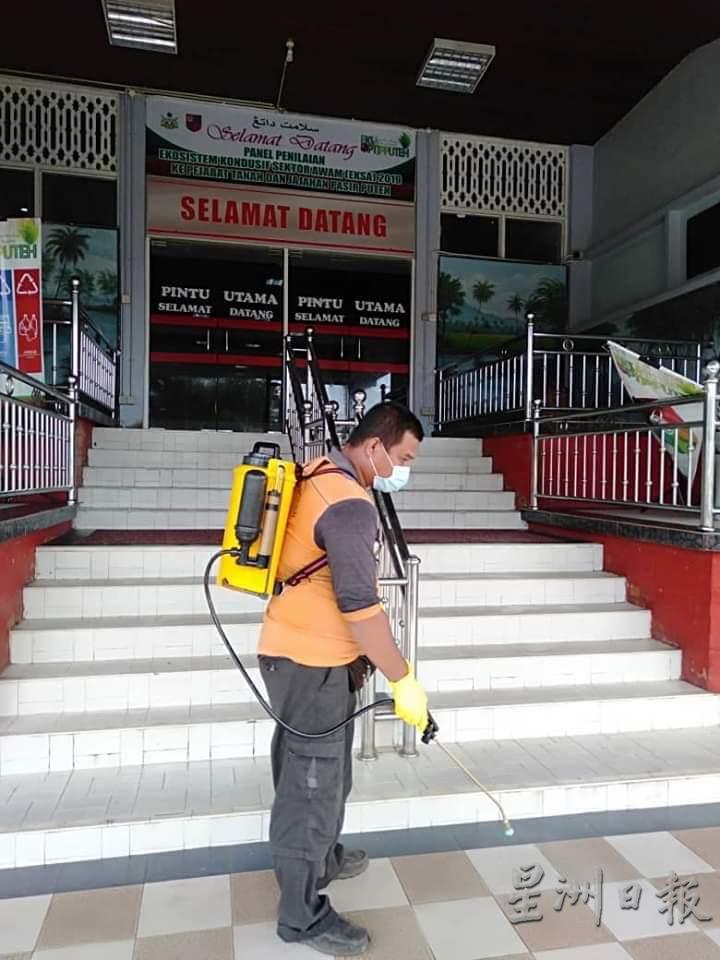 有关人员携带背负式电动喷雾器在政府部门外进行喷消。