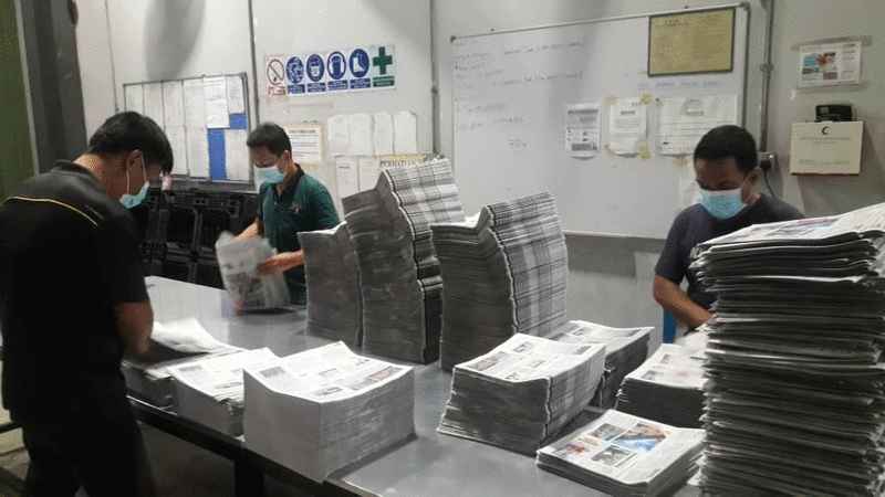 沙巴星洲日报印刷部职员工作时佩戴口罩，遵守防疫措施。