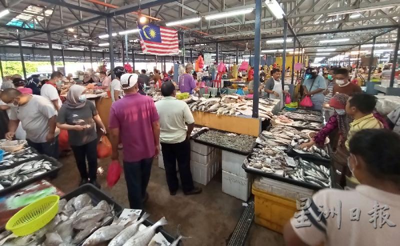 友族消费者围绕鱼类海产档口，选购食材。