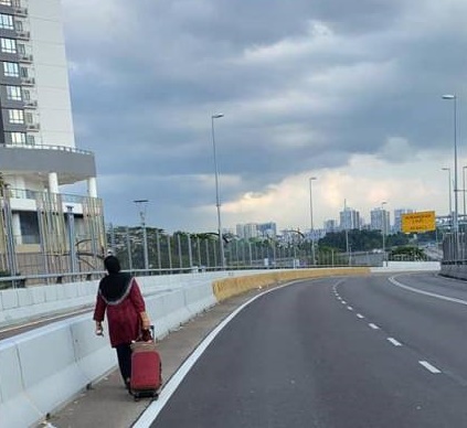 贺蒙苏迪的母亲在新柔长堤走道上拖著行李缓慢前行的背影，感动无数网民。