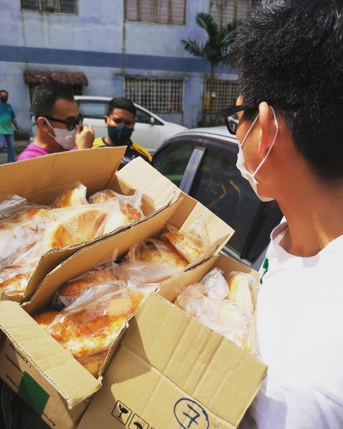 志工拿着多箱面包，准备派送给有需要的人士。