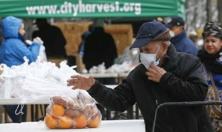 A man receives bags with food from City Harvest food bank. AFP