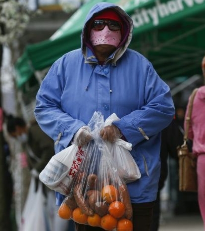 A woman carries bags with food from the City Harvest food bank in Harlem, New York City. AFP